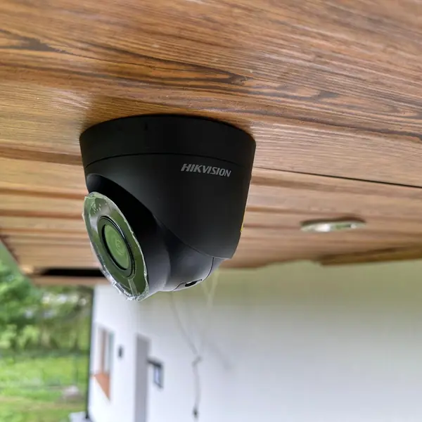 Czarna kamera Hikvision pod drewnianą podbitką