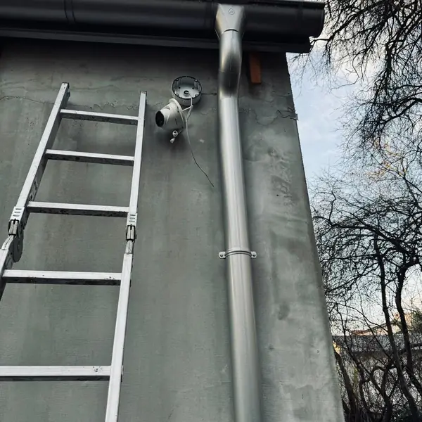Kamera na ścianie budynku, montaż z drabiny